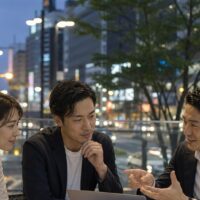 福岡 E-E-A-T強化を実践する地域企業の担当者が、地域情報や顧客の声を確認しながらウェブサイトの信頼性向上について相談している様子